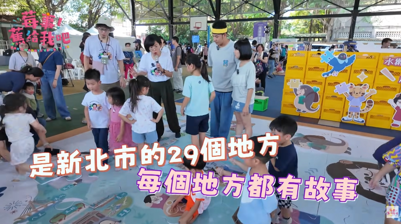 孩子們在「夢幻小隊」互動區，脫下鞋子踩在大地圖上，遊戲中認識新北市29區的在地故事。（圖／《莓事蕉給我吧》）
